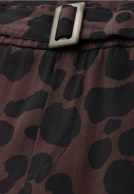 Close-up van bruin-zwart dierenprintstof met een metalen gesp.