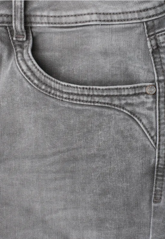 Nahaufnahme einer grauen Jeans mit sichtbarer Tasche und markanten Nähten.