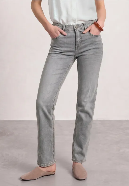 Graue, gerade geschnittene Jeans mit beigen Slippern und weißem Oberteil – schlicht und zeitlos.