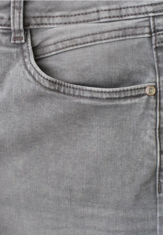 Nahaufnahme einer grauen Jeans mit sichtbarer Tasche und Nahtdetails.