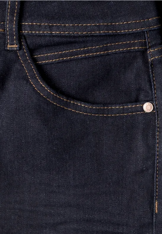 Close-up van een donkerblauwe spijkerbroek met zijzak, contrasterende stiksels en metalen klinknagel.