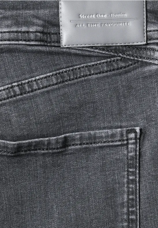 Gros plan d’un jean bleu vu de dos avec poche arrière et étiquette en cuir.