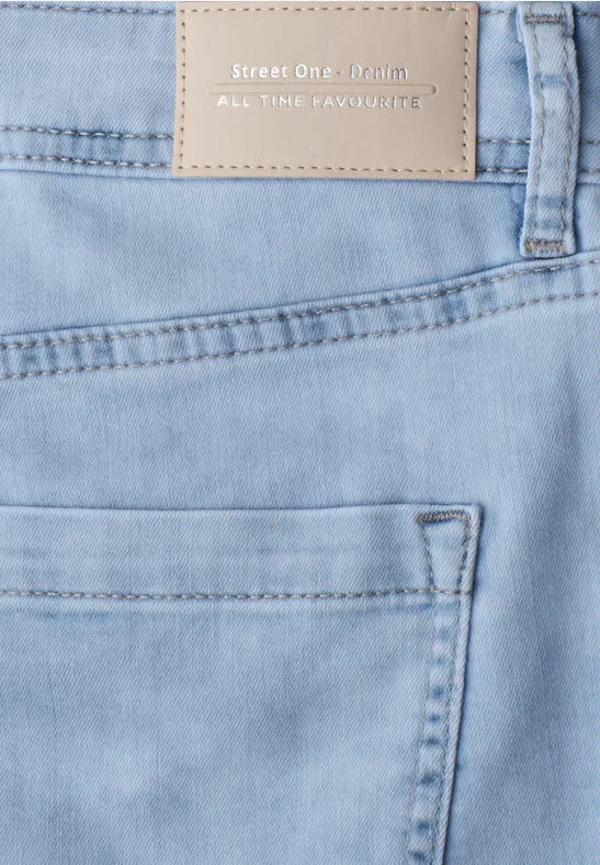 Jean bleu clair avec poche arrière et étiquette beige de marque sur la ceinture.
