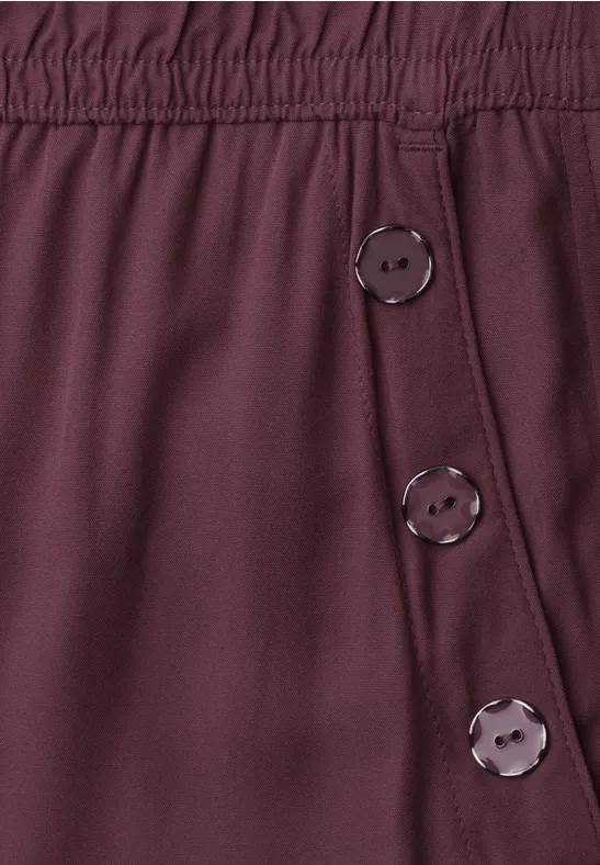 Donkerrood kledingstuk met elastische tailleband en drie zijknopen