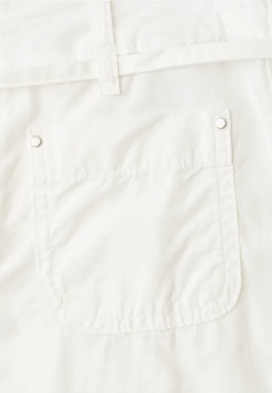Close-up van een opgestikte zak van een witte broek met riemlussen.