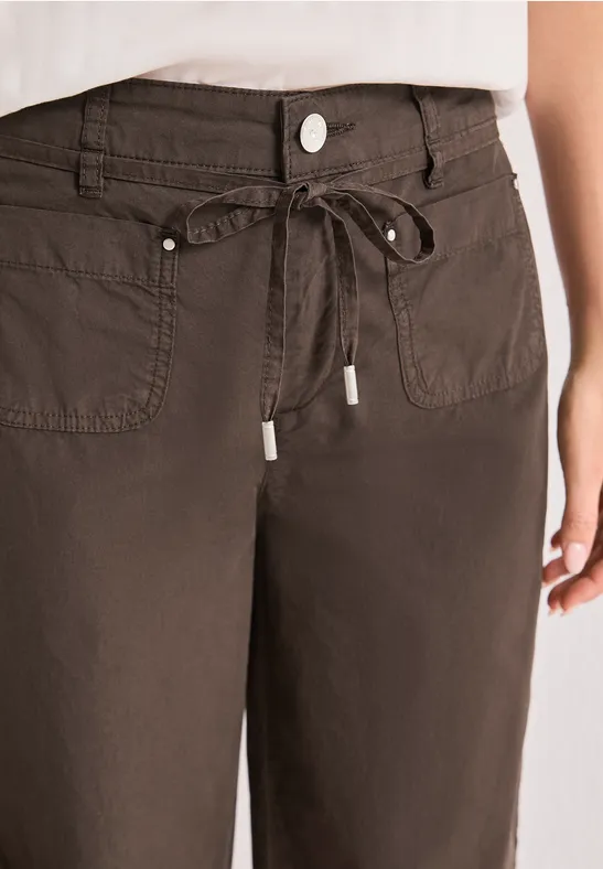 Bruine broek met koordsluiting, knoop en opgenaaide zakken.