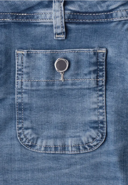 Blauwe spijkerstof met een klein opgenaaid zakje en een zilveren sleutelring erin.