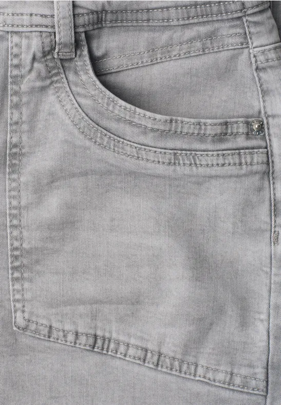 Gros plan d'un jean gris avec poche apparente et coutures fines.