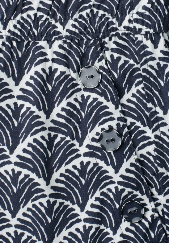 Tissu bleu foncé et blanc à motif en éventail et trois boutons.