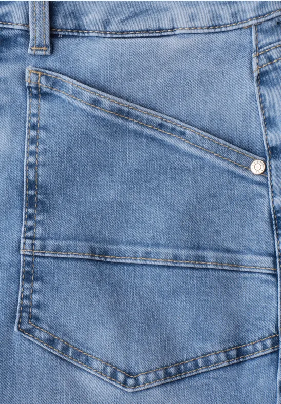 Jean bleu clair avec poche diagonale et coutures apparentes.
