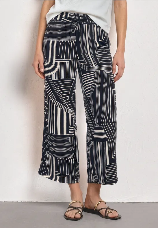 Pantalon ample noir et blanc à motif géométrique.