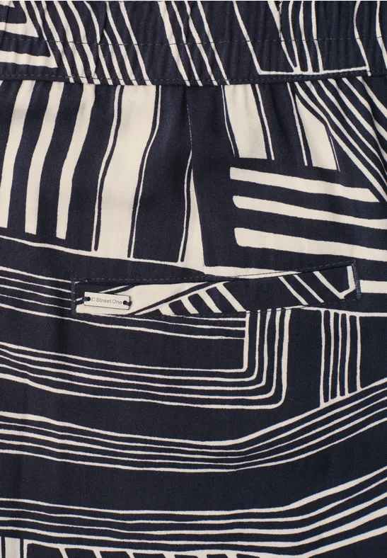 Un tissu bleu foncé orné de lignes blanches géométriques et de blocs aux motifs abstraits.