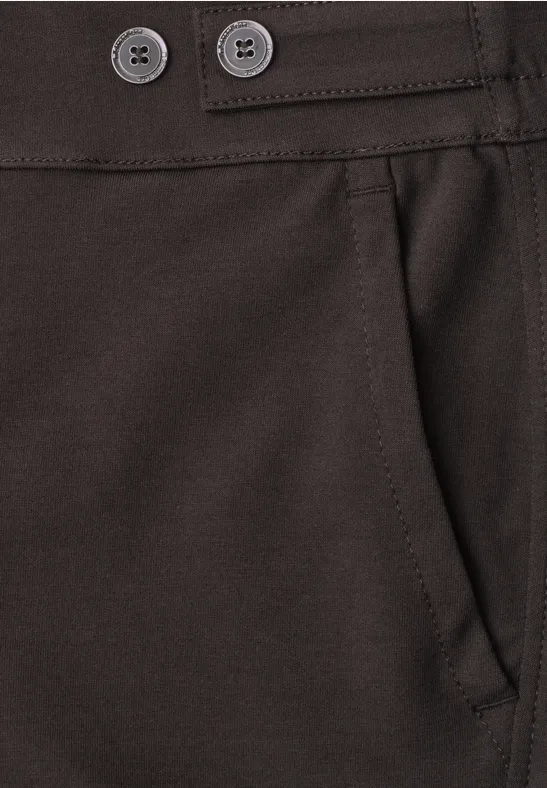 Nahaufnahme einer braunen Hose mit Bund, zwei Knöpfen, Gürtelschlaufen und seitlicher Tasche.