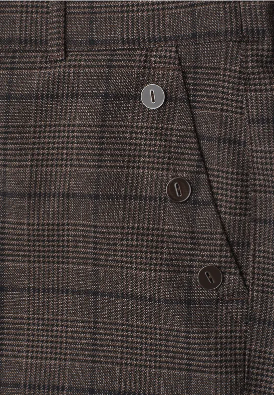 Gros plan d'un pantalon à carreaux brun avec boutons décoratifs latéraux
