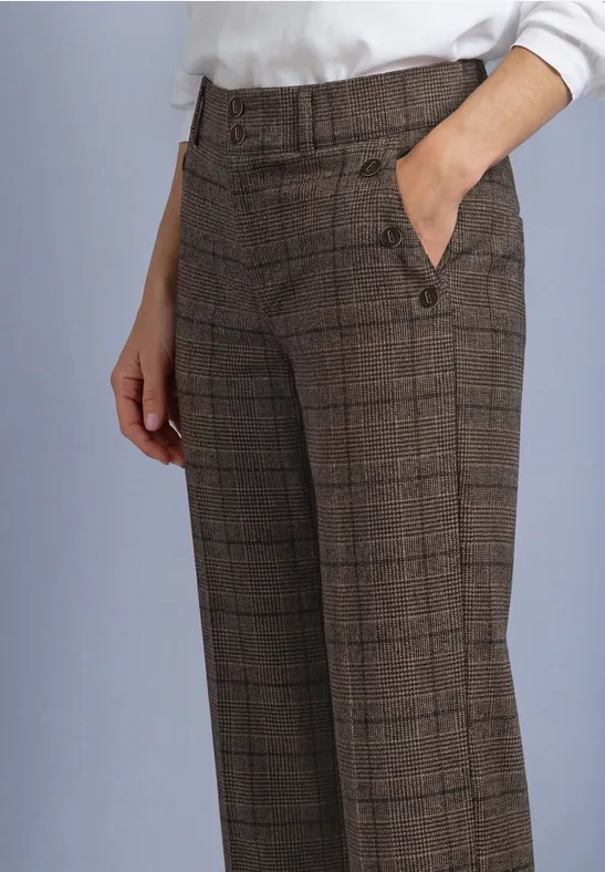 Pantalon femme marron à carreaux, taille haute ceinturée, poches latérales, main dans la poche.