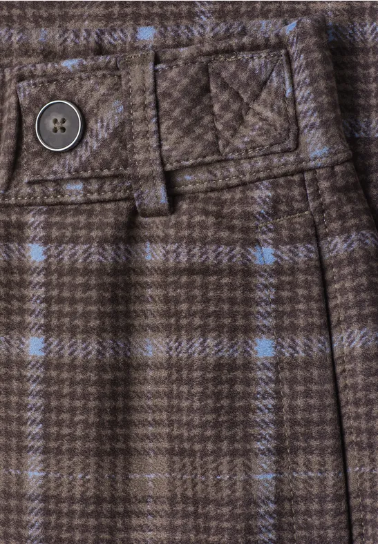 Gros plan sur un pantalon marron à carreaux avec passeceinture, bouton et lignes bleu clair.