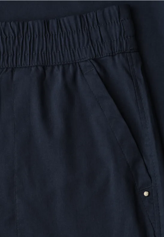 Dunkelblaue Hose mit elastischem Bund und seitlicher Tasche mit Metallniete.