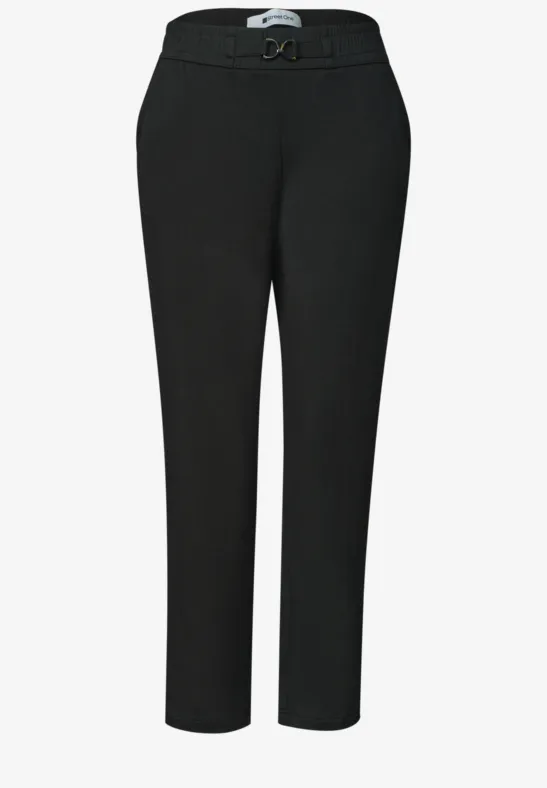 Zwarte pantalon met tailleband, ceintuur en licht taps toelopende pijpen.