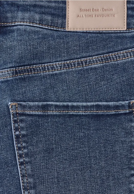 Close-up van een donkerblauwe denim jeans met achterzak en lederen label