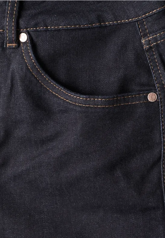 Nahaufnahme einer dunkelblauen Jeans mit Fronttasche, kontrastierenden Ziernähten und Metallnieten.