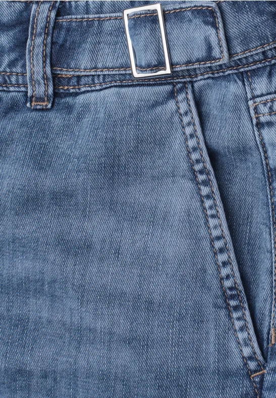 Nahaufnahme einer blauen Jeanshose mit Hosentasche, Bund und Gürtel mit silberner Schnalle.