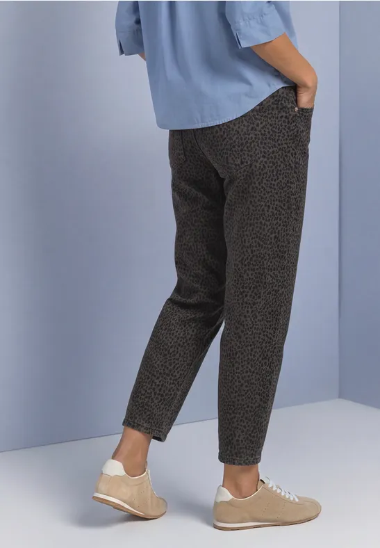 Pantalon slim à motif, chemise bleu clair et baskets beiges sur fond clair.