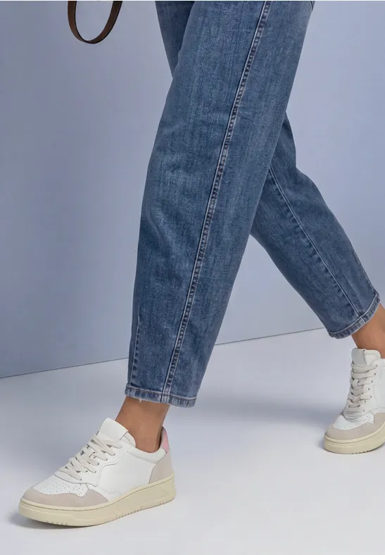 Sneakers blanches et jeans bleus décontractés sur un fond clair