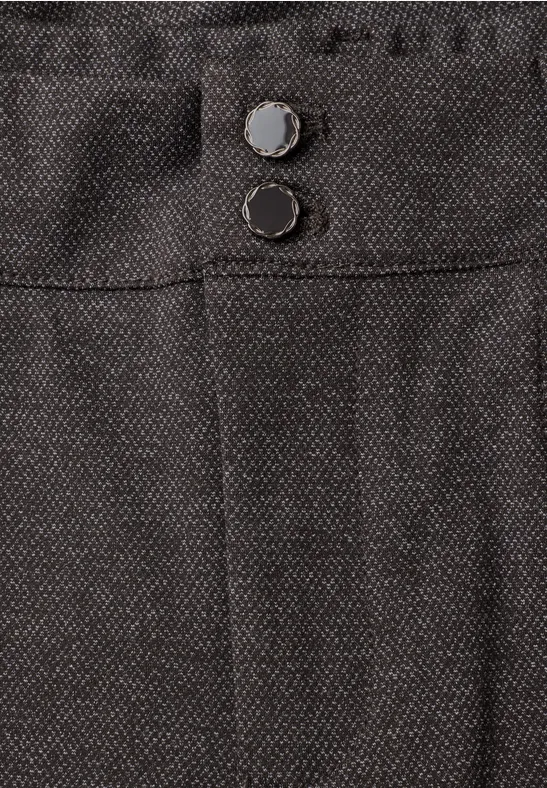 Close-up van een donkere stoffen broek met twee zichtbare knopen in de taille.