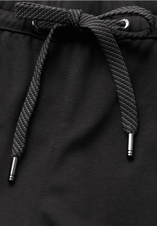 Schwarzer Textilstoff mit mittig geknotetem Kordelzug und silberfarbenen Metallenden.