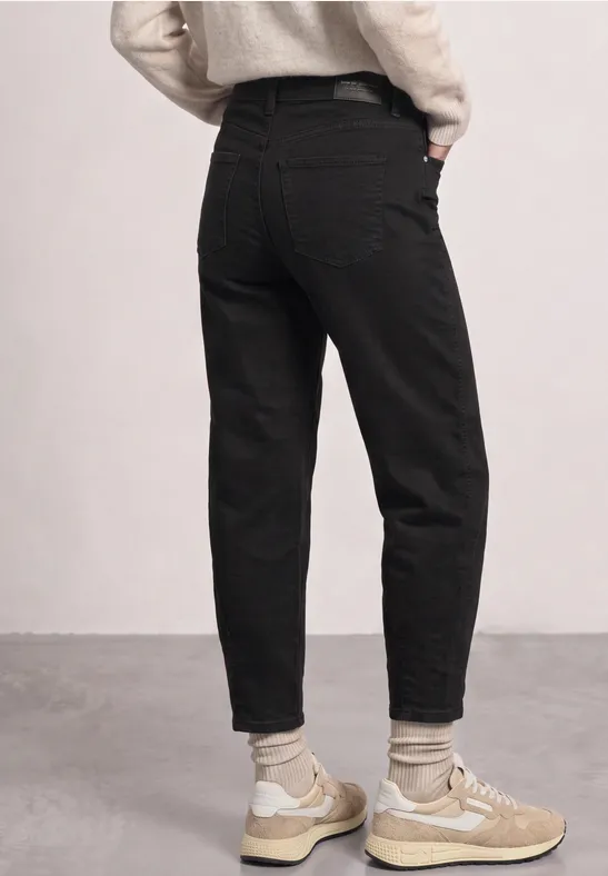 Jean noir, sneakers beiges et chaussettes claires, vue de dos