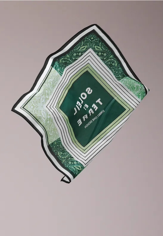 Emballage vert carré avec lignes blanches et texte, légèrement incliné sur fond clair.