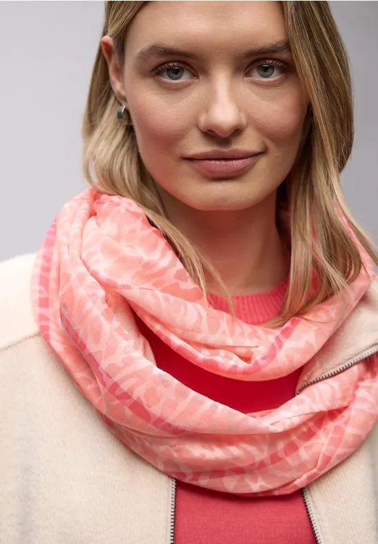 Frau mit hellem Pullover und roséfarbener Schlauchschal.