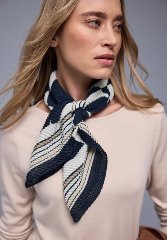 Femme porte un haut beige et un foulard rayé bleu marine et blanc