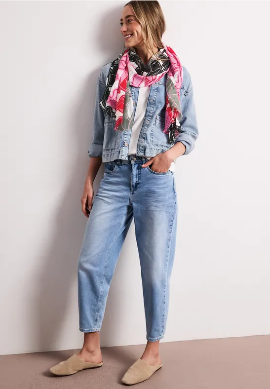 Dame met spijkerjack, blouse, jeans en kleurrijke sjaal