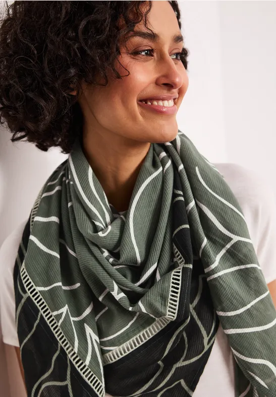 Personne portant un foulard vert à motifs blancs