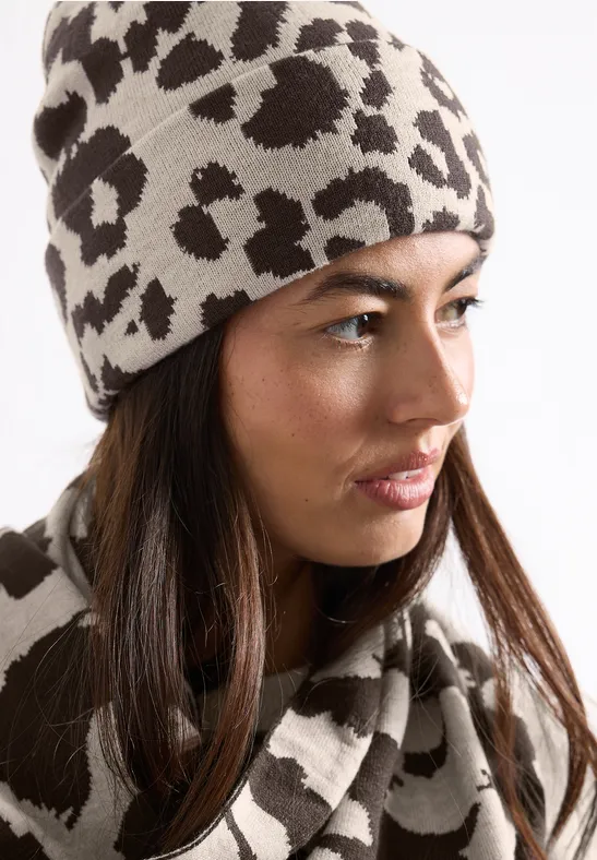 Jeune femme portant un bonnet beige et une écharpe assortie à imprimé léopard.