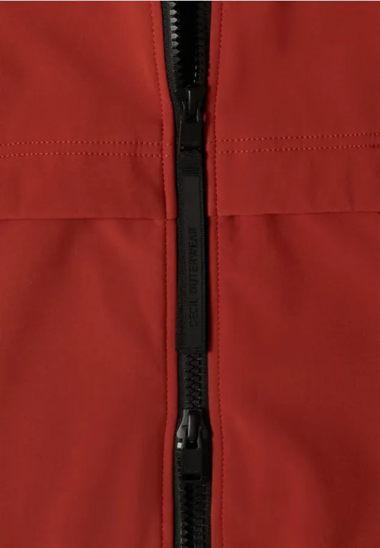 Nahaufnahme einer roten Jacke mit schwarzem Reißverschluss.