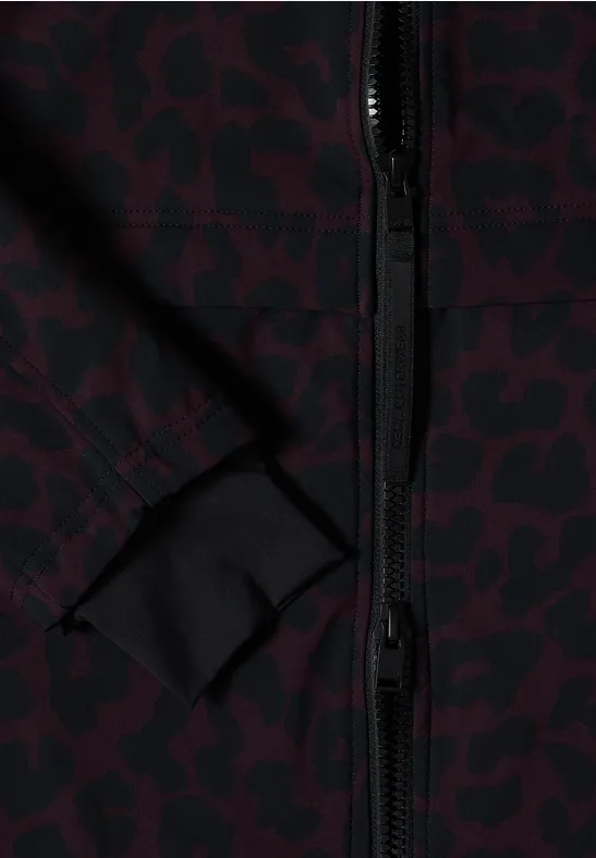 Nahaufnahme einer Jacke mit dunkelrotem Leopardenmuster, schwarzem Reißverschluss und dezenter Taschennaht.
