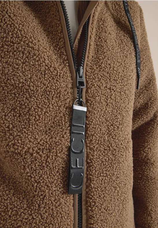 Nahaufnahme eines bräunlichen Teddy-Fleece-Jackenzippers mit Leder-Reißverschlussanhänger