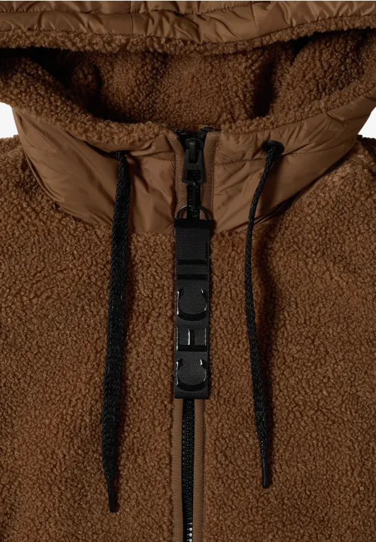 Bruine teddyfleece jas met capuchon, ritssluiting, koordjes en een plastic kliksluiting.