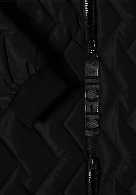 Gros plan sur une veste matelassée noire avec fermeture éclair et tirette de zip imprimée