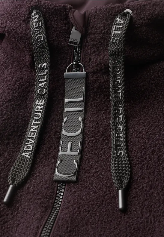 Nahaufnahme eines dunkelvioletten Fleece-Hoodies mit 'Adventure Calls'-Kordeln und 'ICECI'-Label.