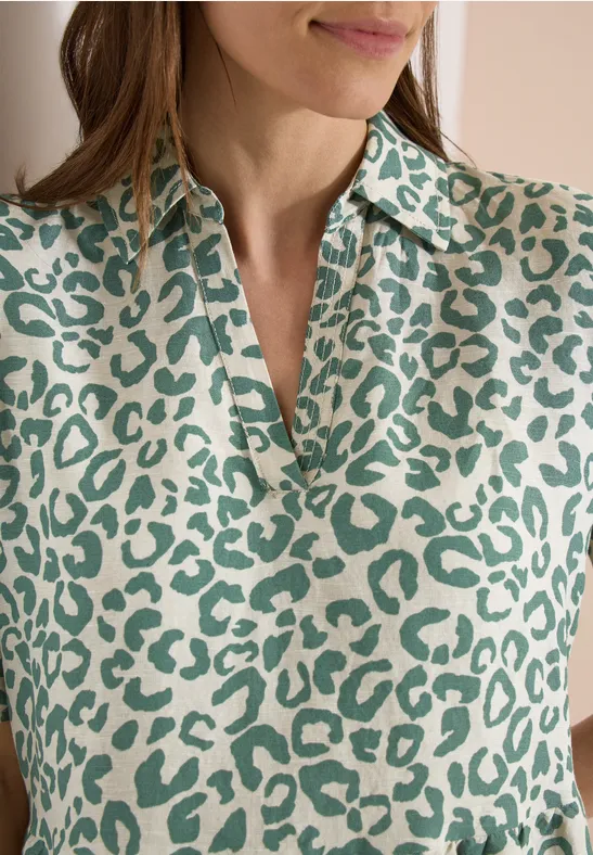 Femme en haut crème à motif léopard vert.