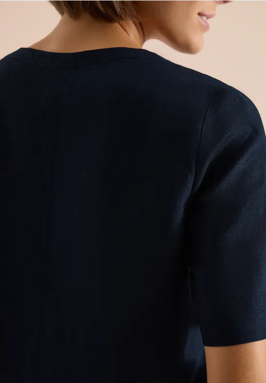 Rückenansicht einer Person in marineblauem Kurzarmshirt mit Rundhals.