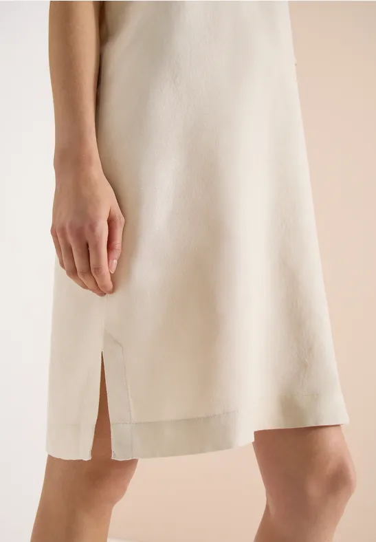 Beiges, knielanges Sommerkleid mit schmalen Trägern und seitlichem Schlitz.