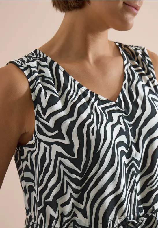 Haut sans manches à col V avec motif zèbre noir et blanc.