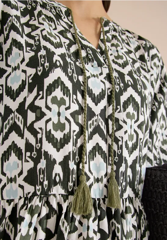 Bluse mit grün-schwarzem ethnischem Muster und Quasten am Ausschnitt