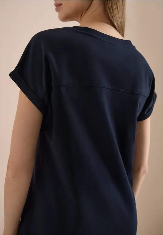 Een vrouw met de rug naar de camera draagt een donkerblauw T-shirt.