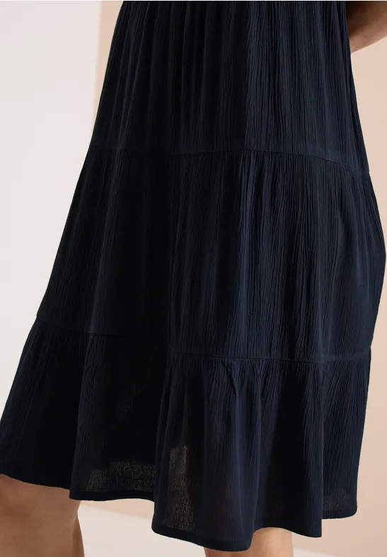 Dunkles, stufiges Midikleid mit feinen Falten, leicht transparentem Saum.