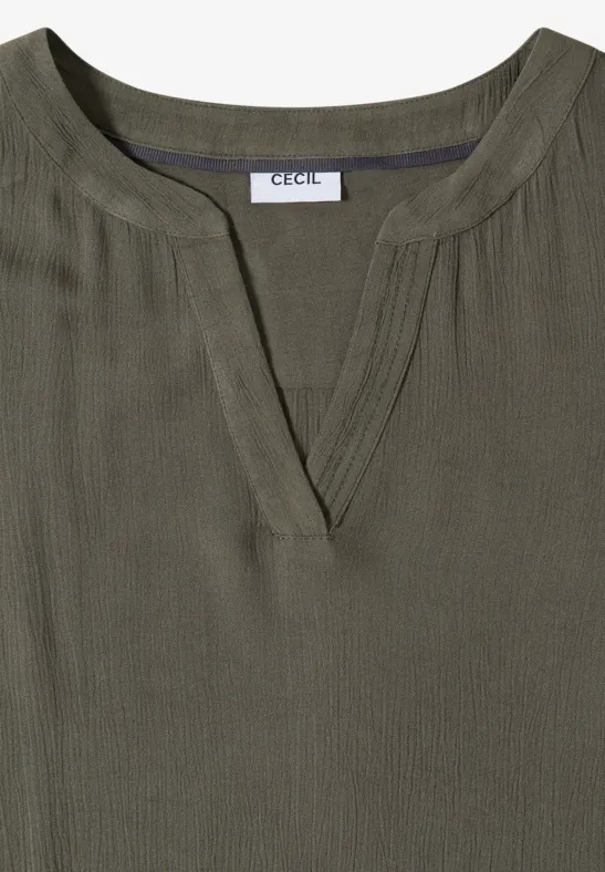 Olivefarbene Bluse mit V-Ausschnitt, feiner Rippstruktur und dezenten Längsfalten, Label 'CECIL' im Nacken.